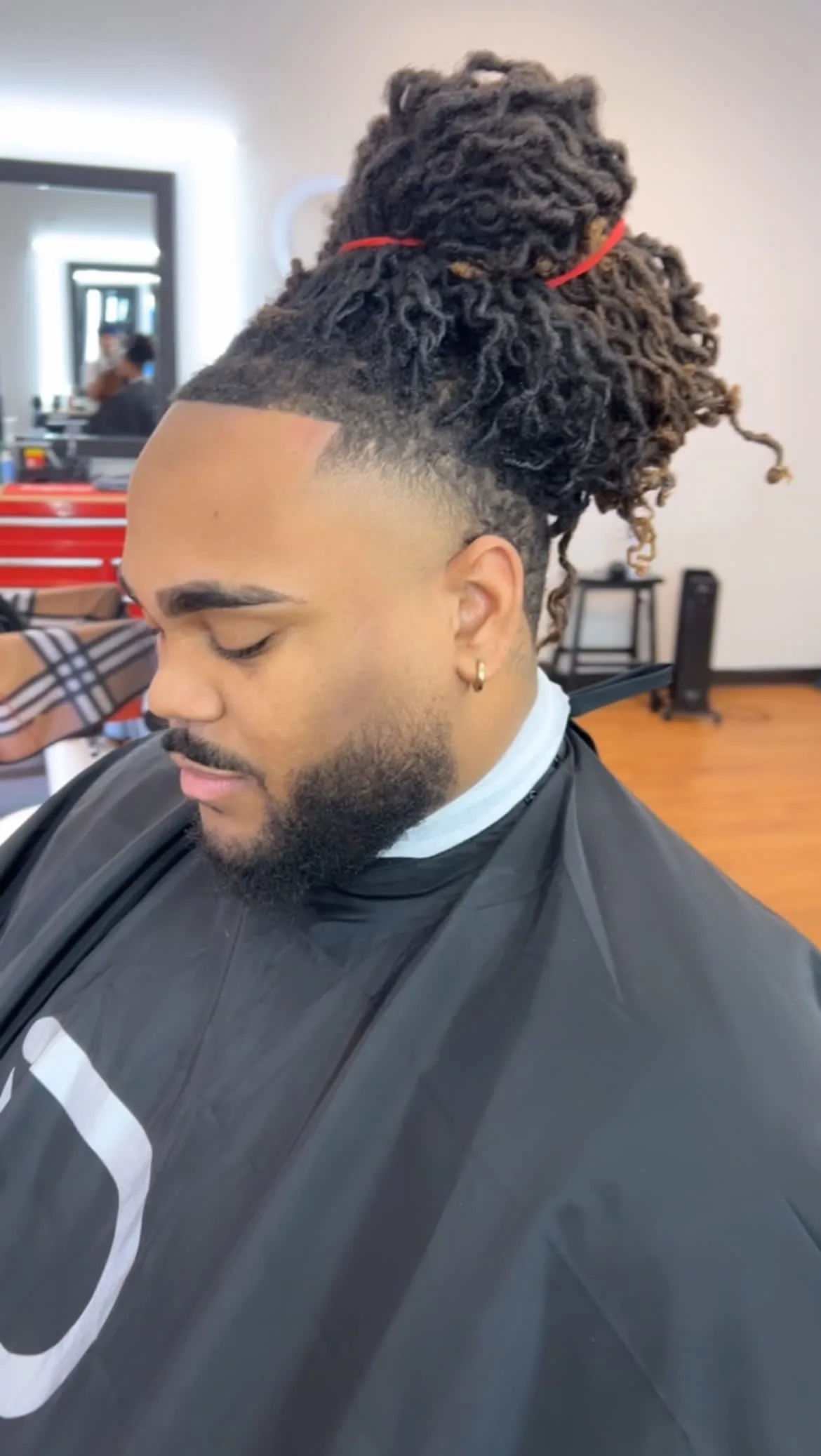 Locs tied up over a clean taper